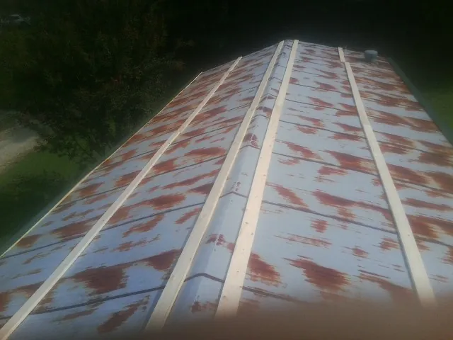 Rusted metal roof panels with new wood purlins before replacement — Storm Damage Roof Repair in Altus by Roofing Brothers