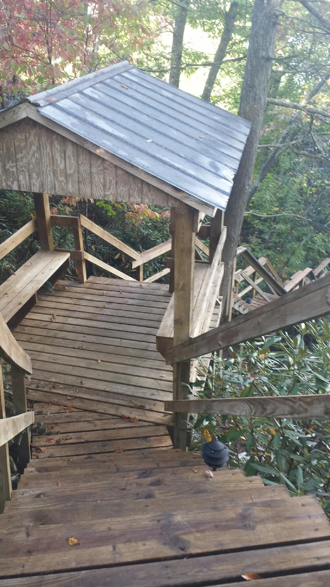Metal roofed shelter over wooden steps on a wooded walkway — Skylight Repair & Installation work by our crew in Altus