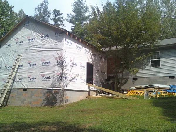 Tyvek wrapped gable on a new room addition beside an existing home in Altus