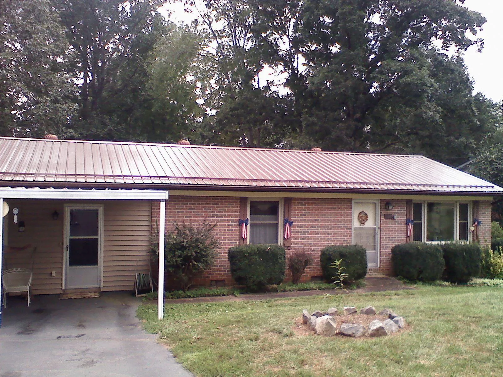 Bronze metal roof and carport on a brick ranch home — Roof Repair work by our crew in Altus