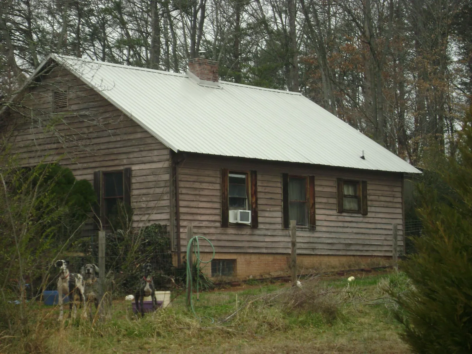 White metal roof on an old wood sided farmhouse, from a Metal Roof Installation job in Altus